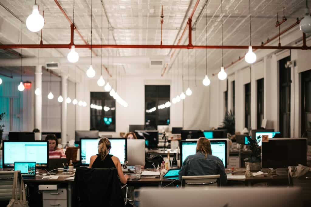 Modern office with employees working on computers at night.