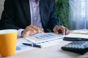 Business professional analyzing financial data on tablet at office desk.