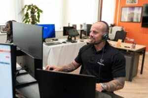 Customer support agent with headset at contact center workstation.